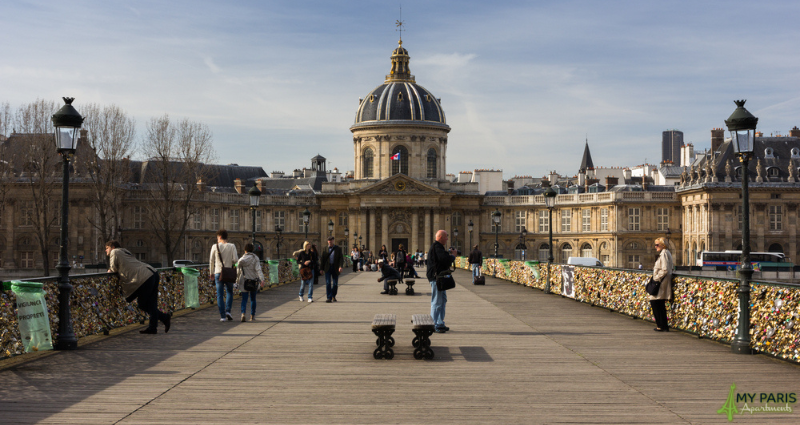 People walking along ‘Pont des Arts’ also knows as the love Lock Bridge